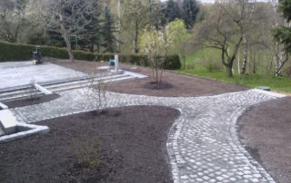 Gehölzflächen und gepflasterte Wege in einem Privatgarten in Dresden-Bannewitz, 2015